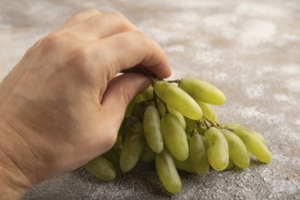 Green grapes on gray concrete background. Side view, close up. healthy food, minimalism