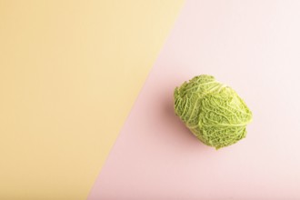 Green lettuce on pink and orange pastel paper background. Top view, copy space, flat lay. healthy
