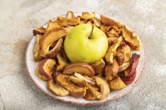 Dried Apples in ceramic bowl on brown concrete background. Side view, copy space, flat lay. healthy
