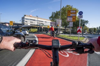 Riding a bike in a bike lane, marked in red to attract the attention of motorists, between 2 lanes,