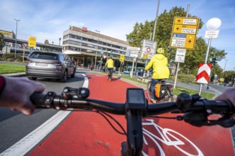 Riding a bike in a bike lane, marked in red to attract the attention of motorists, between 2 lanes,