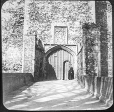 Magic lantern slide of woman standing at doorway entrance to Framingham castle, Suffolk, England,