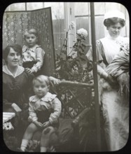 Affluent Edwardian family group indoors with children, mother, nursemaid, UK 1900 - 1930s