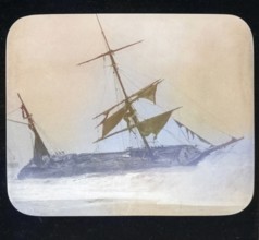 Shipwreck of wooden sailing ship on beach in stormy sea, location unspecified, c 1900 colourised