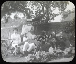 Affluent Edwardian family group men and women with nursemaid holding baby, outdoors in garden
