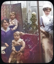 Affluent Edwardian family group indoors with children, mother, nursemaid, UK 1900 - 1930s
