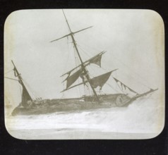 Shipwreck of wooden sailing ship on beach in stormy sea, location unspecified, c 1900