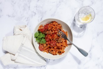 Bigos, Polish dish bigos, on a marble table, stewed meat with cabbage, chorizo sausages, mushrooms,