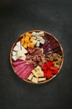 Assortment of cheese meat cuts, on a plate, top view, no people