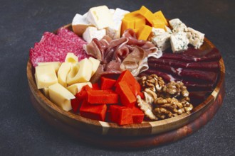 Assortment of cheese meat cuts, on a plate, top view, no people