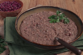 Red bean lobio, a traditional Georgian dish, on a wooden table, homemade