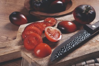 Sliced tomatoes, Black Beauty variety, on a cutting board, top view, on the kitchen table