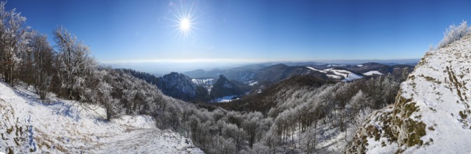 View over the hills and valleys from the mountain with hoarfrost on the branches in winter, Vápec,