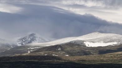 Blick auf schneebedeckte Berggipfel und baumlose Landschaft, Wolken, Pilgerweg Olavsweg, Olavsleden