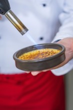 Caramelising a crème brûlée with a Bunsen burner