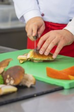 Person cutting mushrooms on a green cutting board