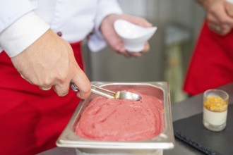 Ice cream is removed from a container with a portioner