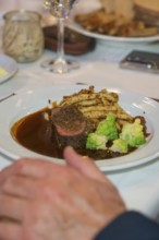 Dish with steak and vegetables on a white plate