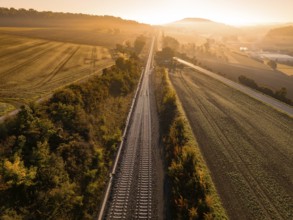 Railway tracks cutting through a rural landscape at sunrise, Hermann Hesse railway, Ostelsheim,
