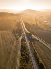 Rural scene with tracks and fields in the light of the rising sun, Hermann Hesse railway,