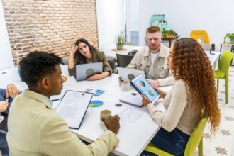 Diverse business professionals collaborating around a conference table in a modern office,