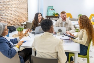 Diverse business professionals working together around a table, sharing ideas and analyzing data