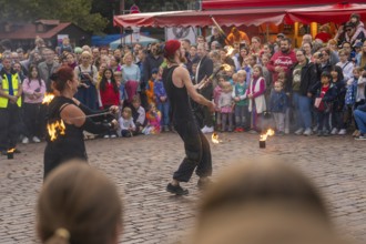 Two artists dressed in black put on a fire show in front of many spectators, Feuernacht,