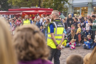 A security guard stands vigil during a well-attended event, Feuernacht, Sindelfingen, Germany