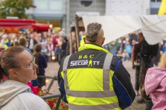 A security guard monitors the event amidst a crowd of visitors at the city festival, Feuernacht,