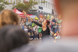 Artist raises torches in the air while many people watch with excitement, Fire Night, Sindelfingen,