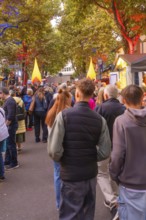 A busy street full of people illuminated by the colourful lights of a festival, Fire Night,