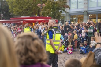 A security guard monitors an event with a gathered crowd, Fire Night, Sindelfingen, Germany