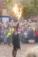 A fire show artist demonstrates her skills in front of a fascinated audience, Feuernacht,