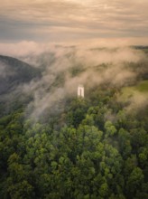 A tower rises out of a misty forest, shrouded by thick clouds, Schönbergturm, Pfullingen, Swabian