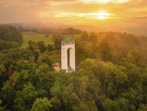 A tower in a peaceful forest landscape at sunset shows golden tones, Schönberg Tower, Pfullingen,