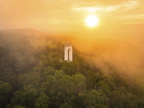 Foggy morning with tower surrounded by trees as the sun rises, Schönberg Tower, Pfullingen, Swabian