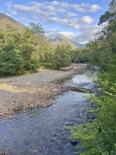 Mountain landscape with a clear flowing river and lush forests, Glen Nevis, Fort William, Scotland,