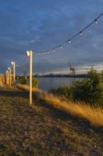 View from the outside area of a restaurant at Lankenauer Höft through a string of lights onto
