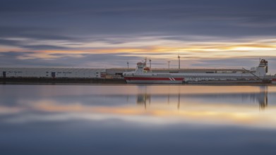 View of a ship moored at the quay in Neustadt harbour at sunset, long exposure, Weser, Bremen,