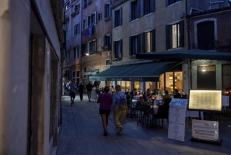 Venice, Italy - 2 September 2025: People stroll in San Marco in Venice at sunset during the 82nd