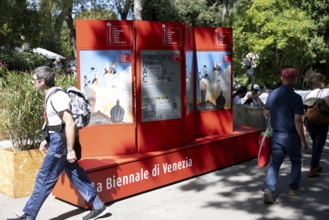 Venice, Italy - 3 September 2025: People walk past a billboard advertising the festival during the