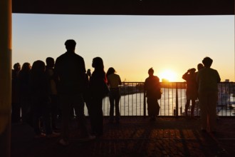 Crowd enjoying the view from the Elbphilharmonie over the Elbe at sunset, silhouettes, Plaza