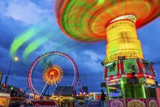 Illuminated chain carousel in motion, behind the Ferris wheel in motion, Festwiese, Theresienwiese,