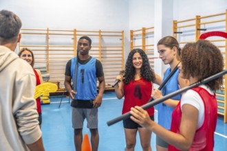 Multi ethnic floorball team gathered in a gym, attentively listening to their coach's instructions