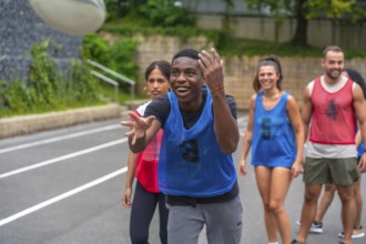 Male rugby player wearing a blue training bib is catching a ball during a practice session,