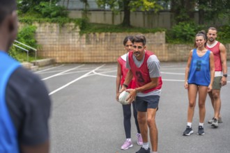 Group of athletes wearing numbered jerseys practicing passing drills on an outdoor court, focusing