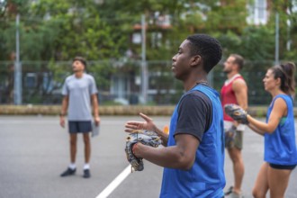 Group of baseball players wearing blue training jerseys are practicing catching fly balls in an