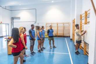 Hockey coach drawing a game plan on whiteboard while explaining strategy to players divided in two