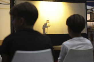 A Syrian puppeteer entertains children at the Damascus International Fair by imitating the role of