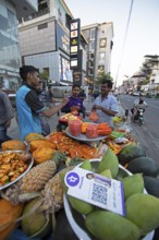 Indian men buying fresh fruit at a roadside stall, Begaluru or Bangalore, Karnataka, India